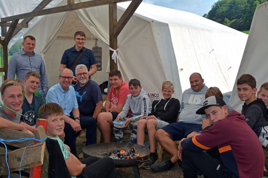 Das gemütliche Lagerfeuer gehört ebenso zum Padercamp wie die tägliche Bibelarbeit – Landrat Manfred Müller besucht Ferienfreizeit, neben ihm sitzt Pastor Heinrich Friesen, dahinter stehend v.l. Organisatoren Heinrich Heinrichs und Pastor Arthur Schmidt sowie sitzend dritter von rechts Erlebnispädagoge David Gerber.  Bildrechte: Kreis Paderborn/ Amt für Presse- und Öffentlichkeitsarbeit, Meike Delang